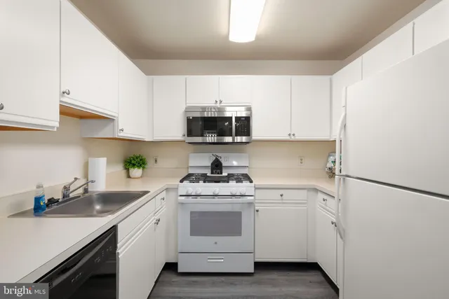 a kitchen with white cabinets and white appliances