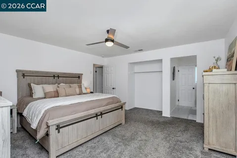 a bedroom with a bed a chandelier and a window