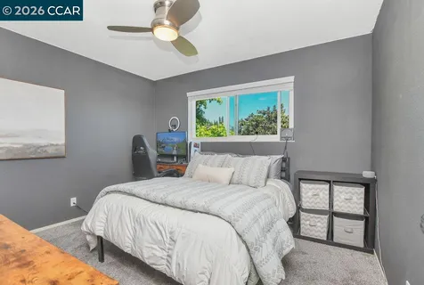 a bedroom with a bed and a painting on the wall