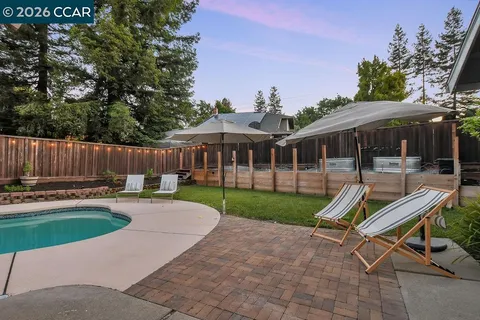 a view of a patio with a table chairs and a yard