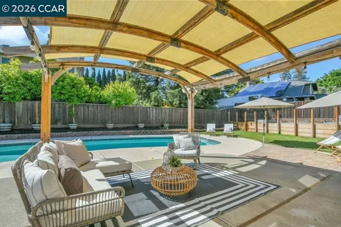 a view of a patio with table and chairs under an umbrella