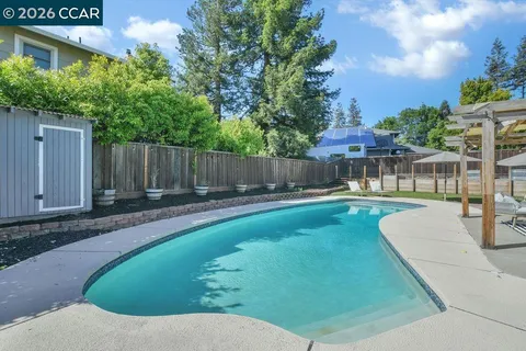 a view of a swimming pool with a patio and a garden