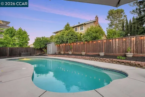 an aerial view of a house with a yard and a large pool