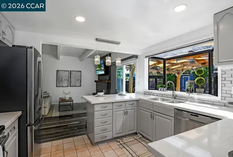 a kitchen with stainless steel appliances granite countertop a sink a stove and cabinets