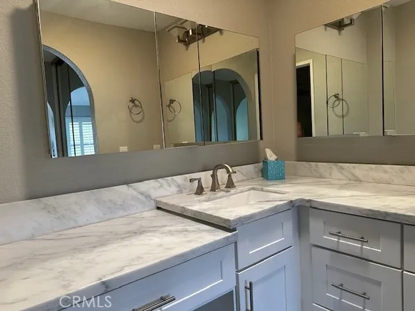 a bathroom with a granite countertop sink and a mirror