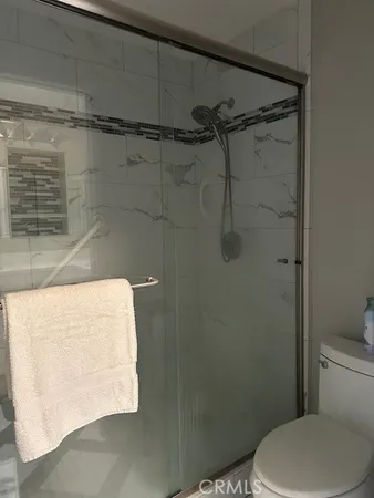 a white toilet sitting next to a shower