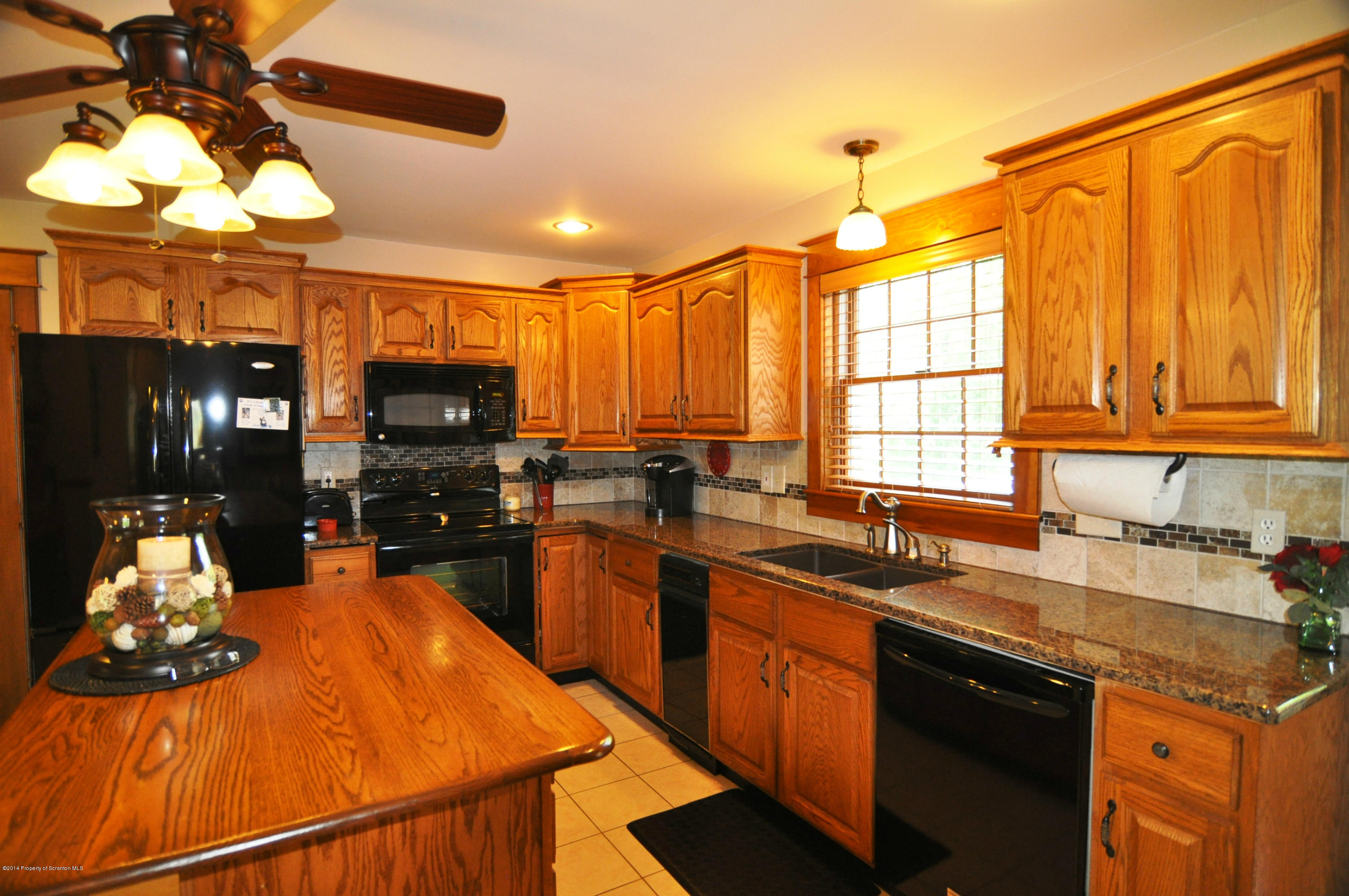 116 Griffin Road Moscow, PA 18444 - Photo 13 of 50 a kitchen with kitchen island granite countertop a sink appliances cabinets and a counter top space