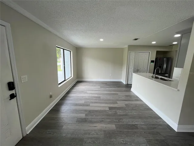 a view of a hallway with wooden floor and a living room