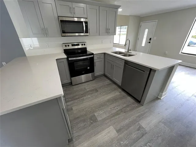 a kitchen with stainless steel appliances a stove a sink and a microwave