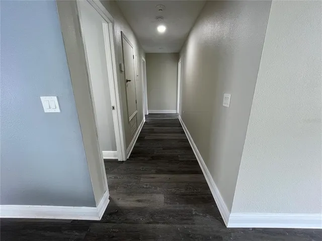 a view of a hallway with wooden floor and entryway