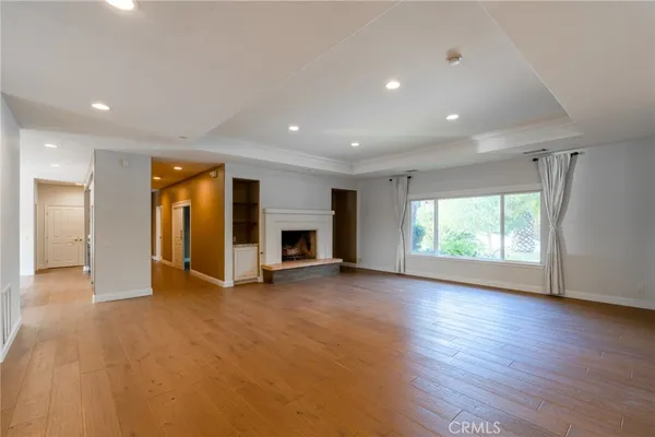 an empty room with wooden floor and ceiling fan