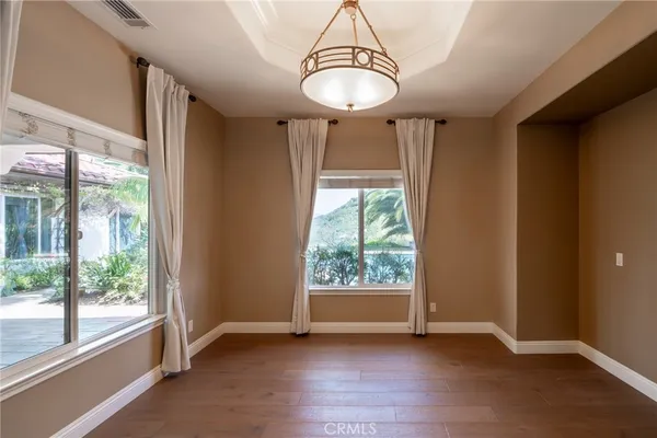 a view of a hallway with wooden floor and a ceiling fan