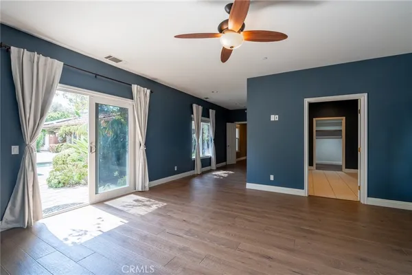 a view of a livingroom with a ceiling fan window and wooden floor