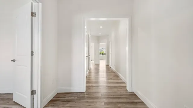 a view of a hallway with wooden floor