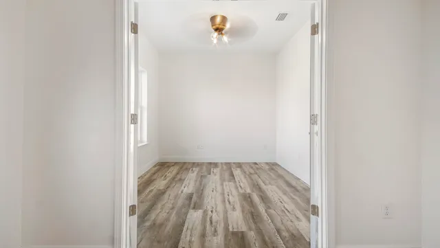 a view of a room that has wooden floor and a window