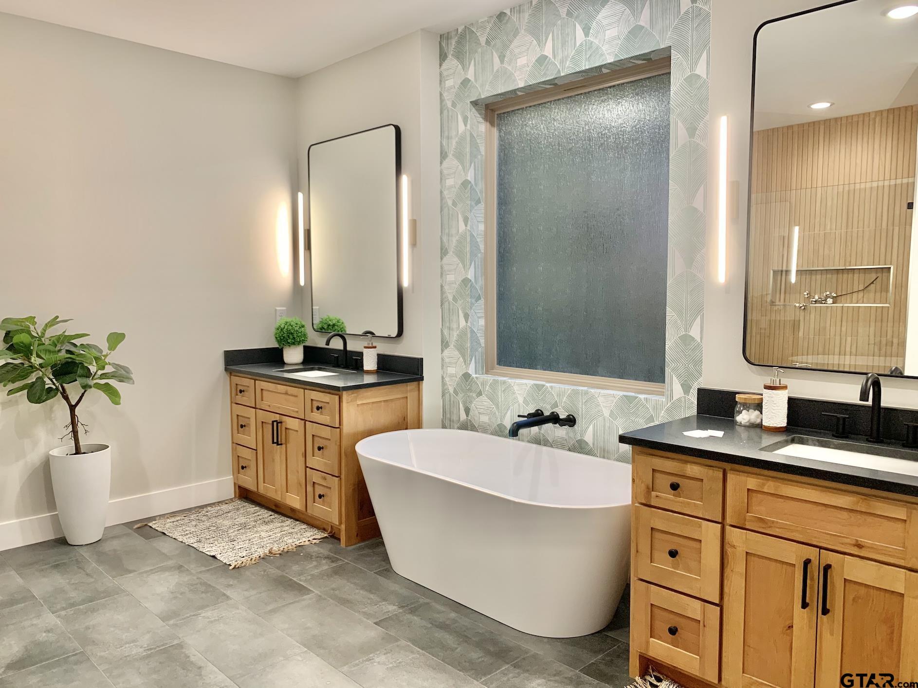 9115 Long Branch Tyler, TX 75703 - Photo 28 of 39 a bathroom with a double vanity sink a mirror and a bathtub