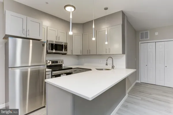 a kitchen with stainless steel appliances a refrigerator sink and microwave