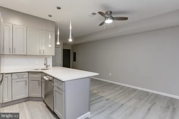 a kitchen with a sink cabinets and wooden floor