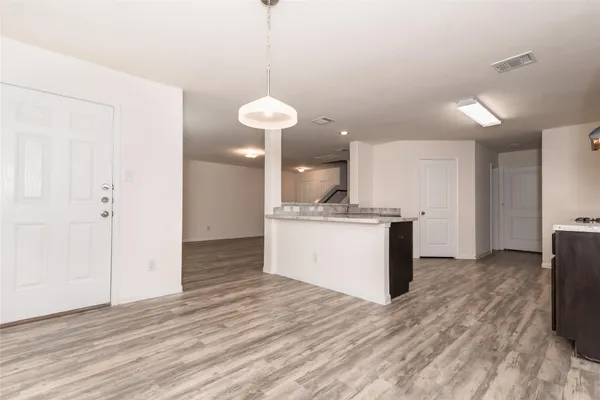 a view of kitchen with granite countertop cabinets and refrigerator