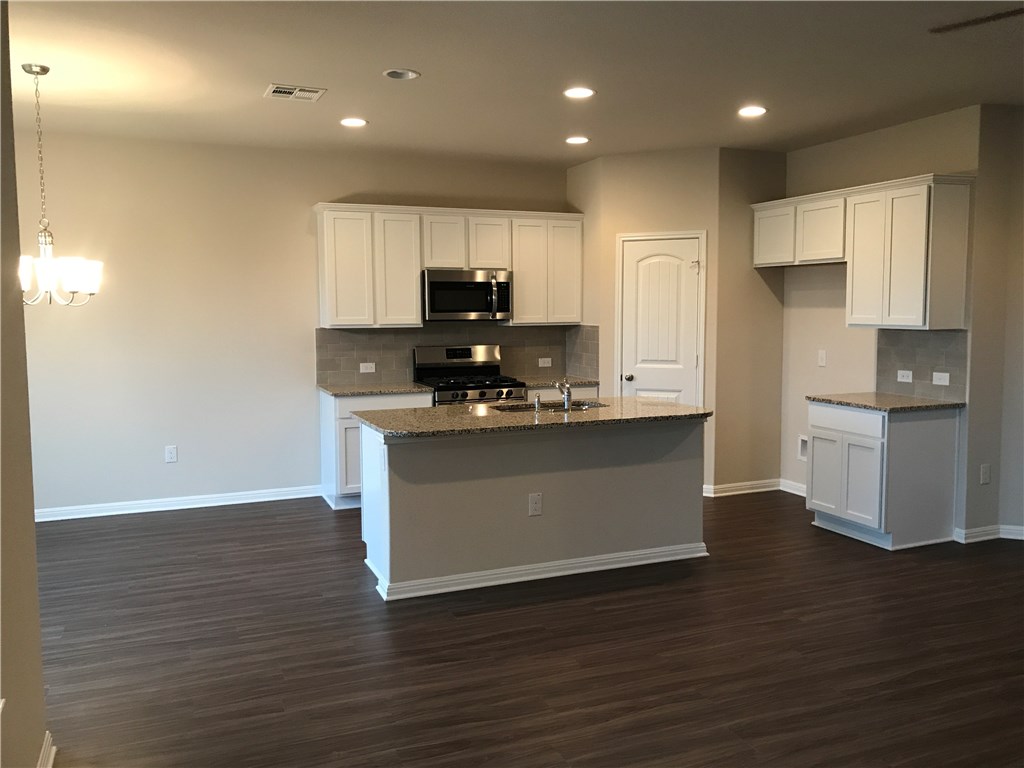 4313 Buffalo Ford Road Georgetown, TX 78628 - Photo 16 of 36 a kitchen with kitchen island stainless steel appliances a sink and refrigerator