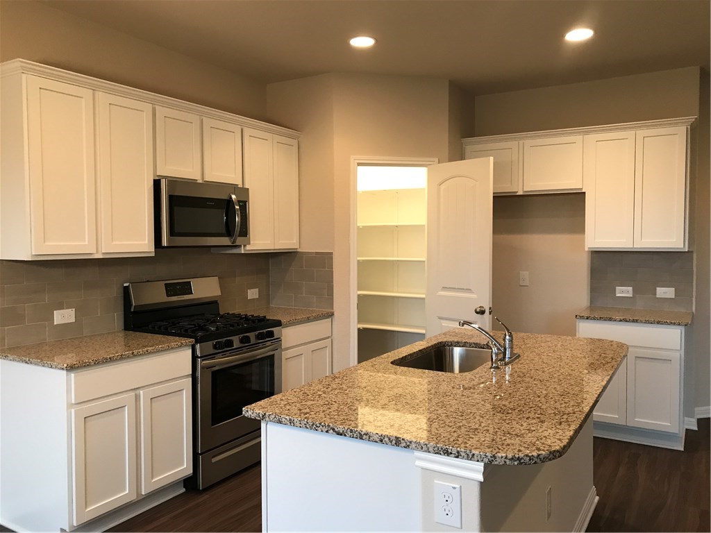 4313 Buffalo Ford Road Georgetown, TX 78628 - Photo 2 of 36 a kitchen with stainless steel appliances granite countertop a sink a stove and a microwave