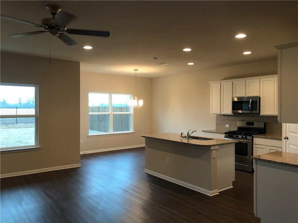 4313 Buffalo Ford Road Georgetown, TX 78628 - Photo 4 of 36 a kitchen with stainless steel appliances kitchen island granite countertop a stove a sink and a microwave