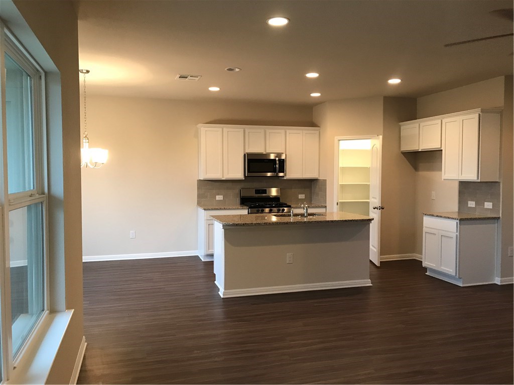 4313 Buffalo Ford Road Georgetown, TX 78628 - Photo 6 of 36 a kitchen with a refrigerator and a stove top oven