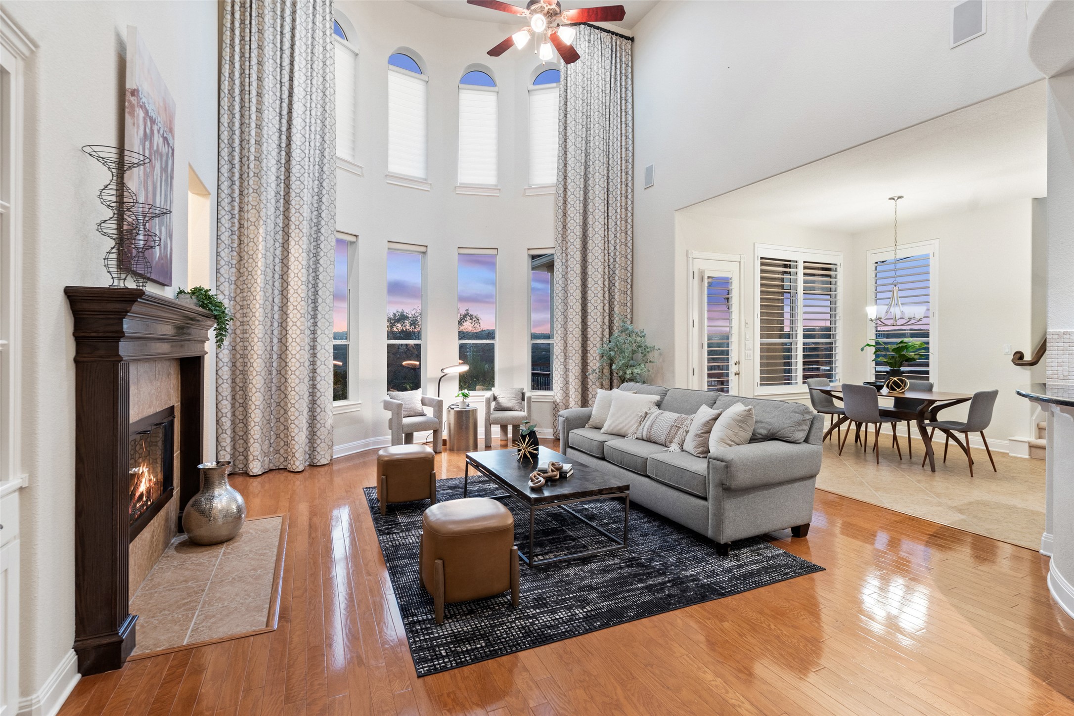 a living room with furniture fireplace and large windows