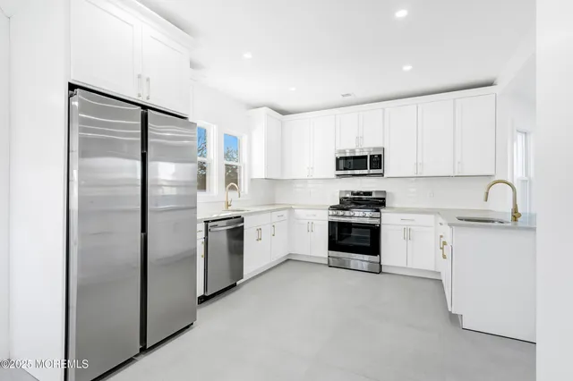 a bathroom with a sink a toilet a mirror and shower