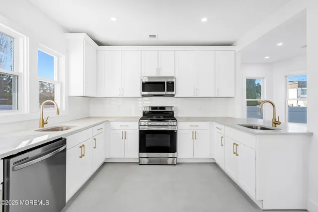 a view of a white house with a yard and a large tree
