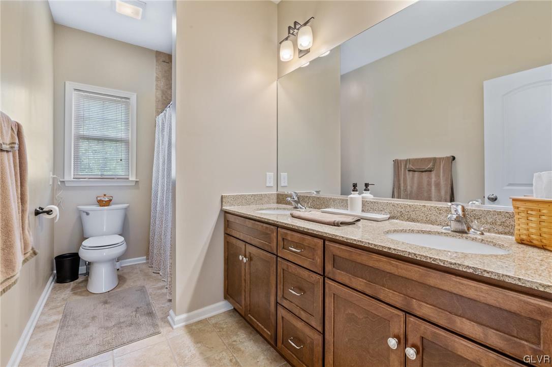 315 Bougher Hill Road Easton, PA 18042 - Photo 11 of 20 a bathroom with a granite countertop sink a toilet and a mirror