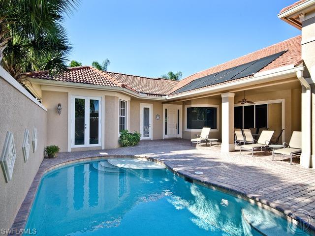 5066 Rustic Oaks Circle Naples, FL 34105 - Photo 3 of 12 a swimming pool with outdoor seating and yard