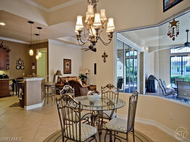 5066 Rustic Oaks Circle Naples, FL 34105 - Photo 6 of 12 a view of a dining room with furniture and chandelier