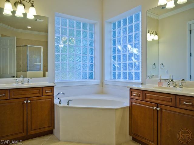 5066 Rustic Oaks Circle Naples, FL 34105 - Photo 9 of 12 a bath room with a sink and a mirror