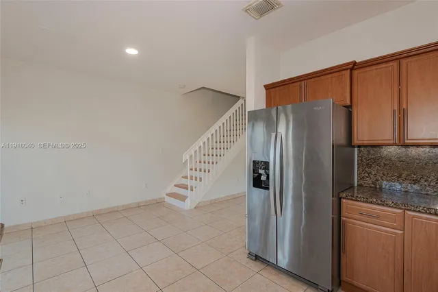 a kitchen with stainless steel appliances granite countertop a sink a stove a refrigerator and cabinets