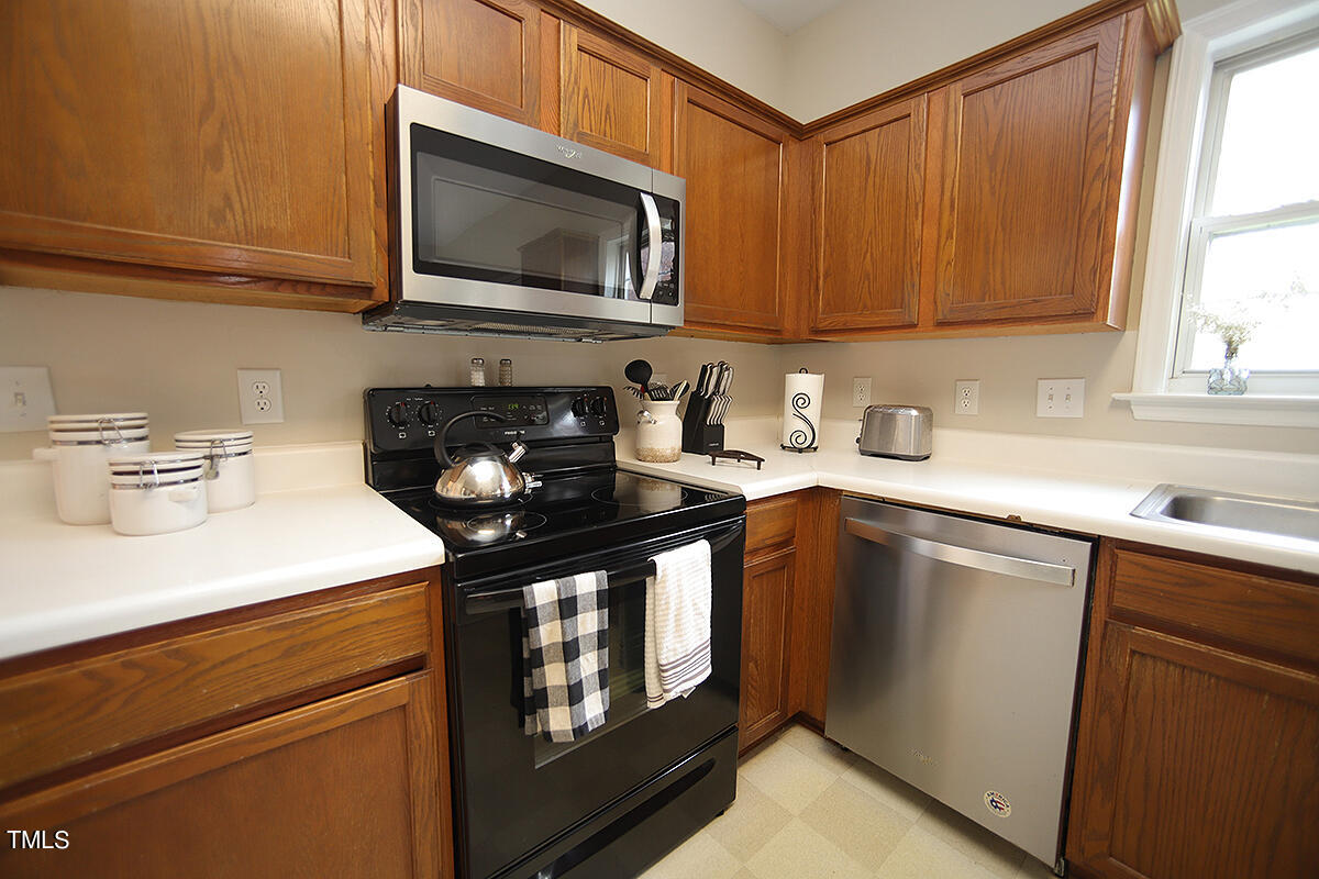 3557 Dewing Drive Raleigh, NC 27616 - Photo 12 of 32 a kitchen with stainless steel appliances granite countertop a sink a stove a microwave and cabinets