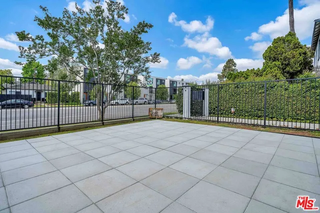 a view of a house with a small yard and wooden fence