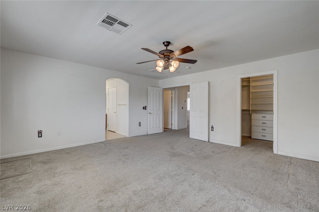 1479 Orange Jubilee Road Henderson, NV 89014 - Photo 19 of 36 Ample closet storage and a ceiling fan create a comfortable and functional primary bedroom space.