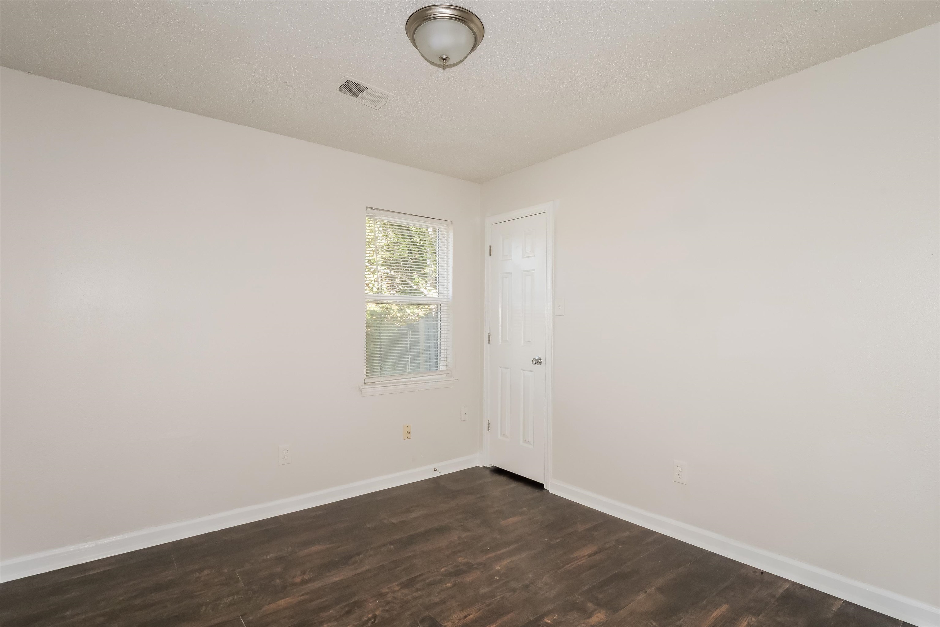 3824 Windermere Road Memphis, TN 38128 - Photo 11 of 16 an empty room with wooden floor and windows