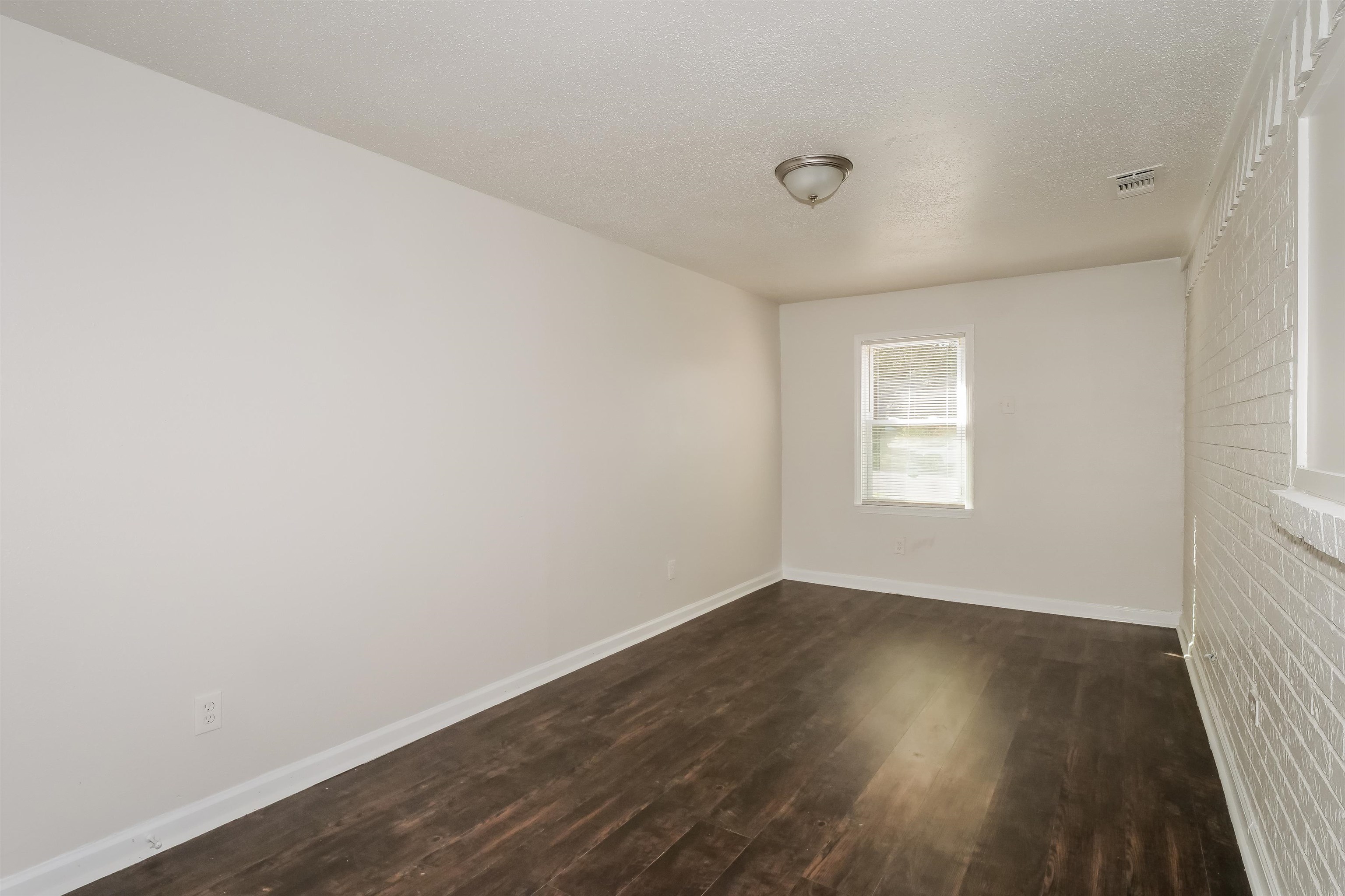 3824 Windermere Road Memphis, TN 38128 - Photo 13 of 16 an empty room with wooden floor and windows