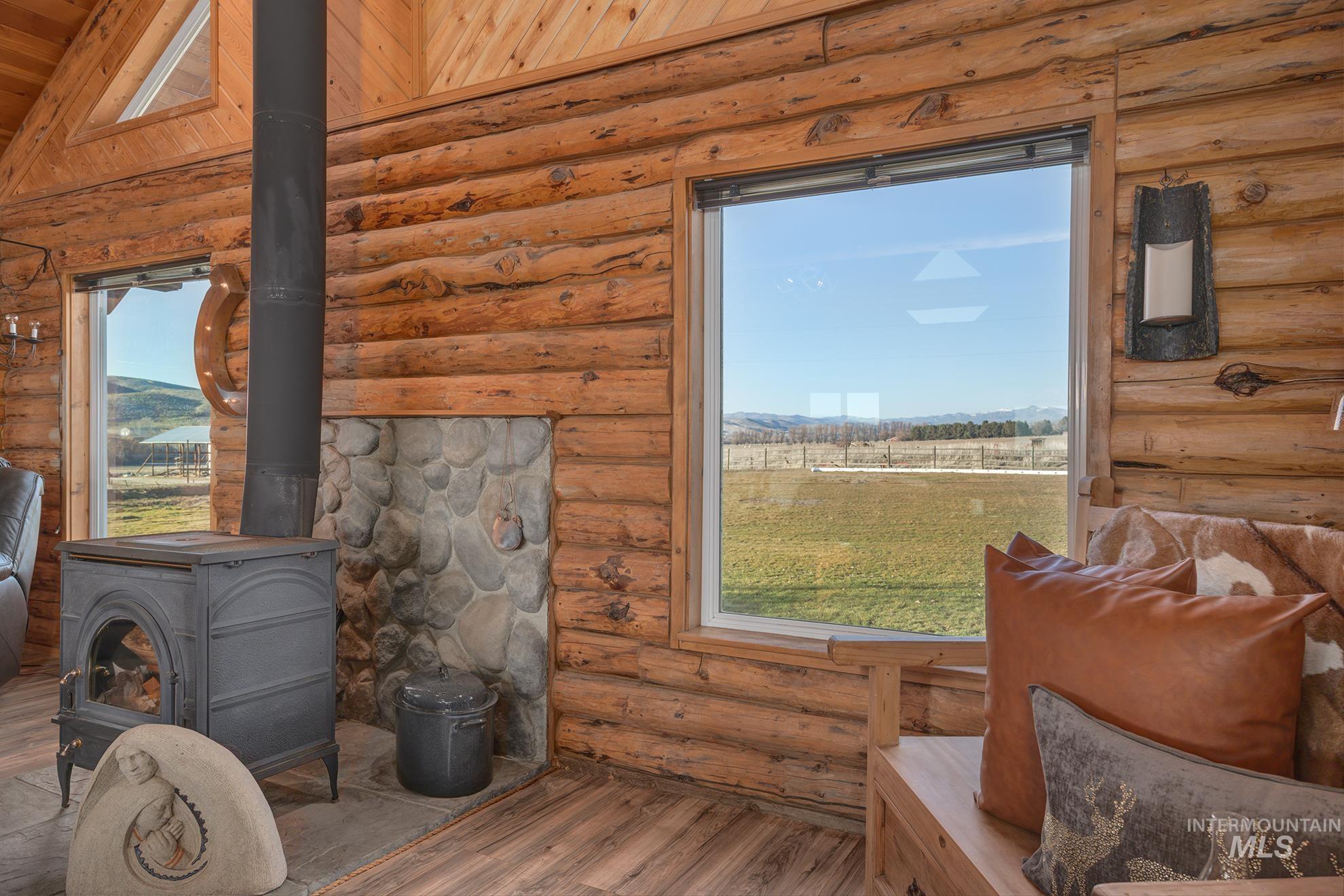 1855 Jones Road Weiser, ID 83672 - Photo 6 of 34 Detailed view of a wood stove, wood finished floors, and log walls