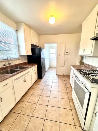 a kitchen with a sink a stove and a refrigerator