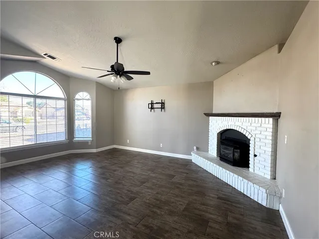 a view of an empty room with a fireplace and a window