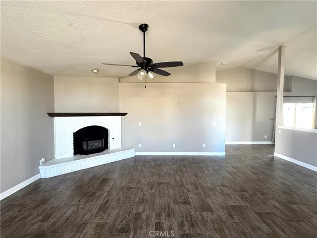 a view of an empty room with a fireplace and a window