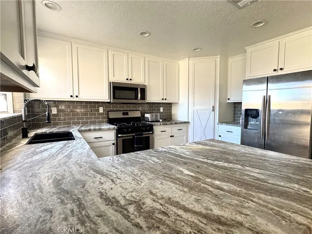 a kitchen with stainless steel appliances a refrigerator sink and cabinets