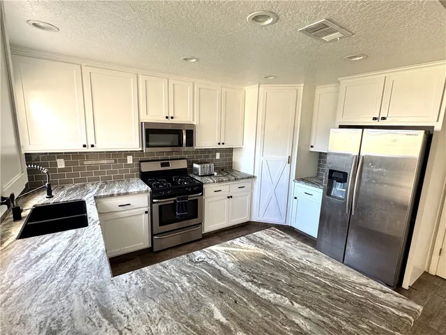 a kitchen with a refrigerator stove and microwave