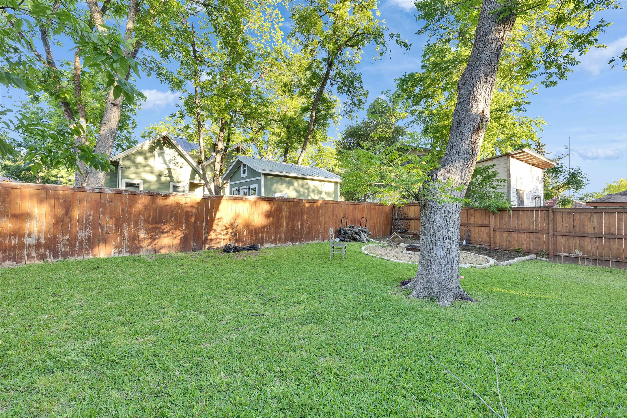 4607 Evans Avenue, Unit B Austin, TX 78751 - Photo 28 of 34 Expansive backyard featuring a green lawn, mature trees, and a perimeter wood fence