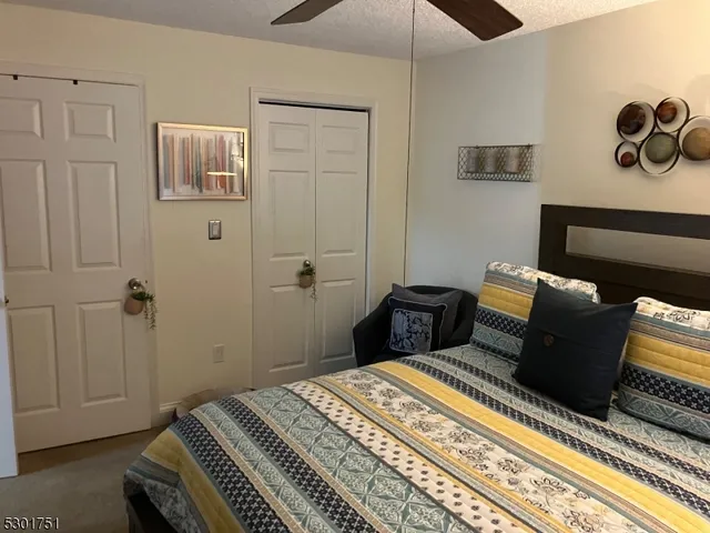 a bedroom with a bed and a flat tv screen on dresser