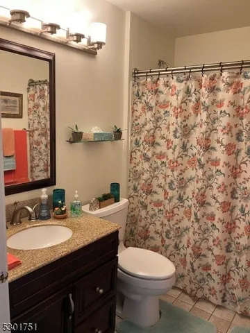 a bathroom with a granite countertop sink toilet a mirror and shower