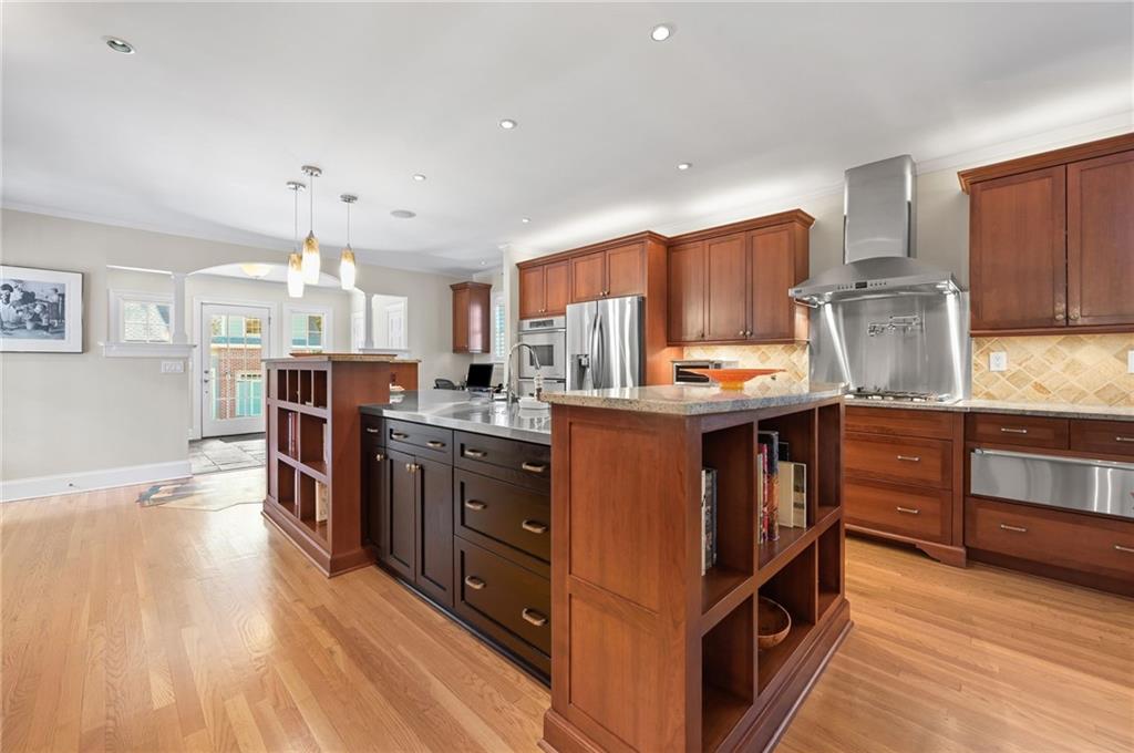 1735 Johnson Road Northeast Atlanta, GA 30306 - Photo 14 of 54 a kitchen with stainless steel appliances kitchen island granite countertop a stove top oven a sink dishwasher and cabinets with wooden floor